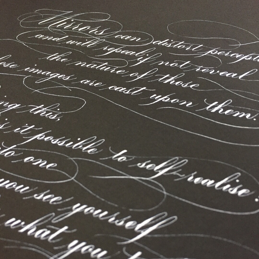 close-up of white flourished copperplate calligraphy on black background
